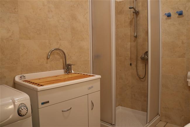 bathroom with shower and washing machine